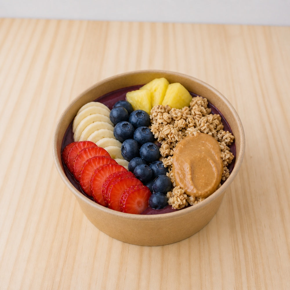 Acai bowl from the deli topped with strawberry, banana, blueberry, pineapple, granola and peanut butter